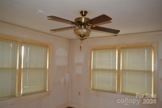 spare room featuring ceiling fan and crown molding