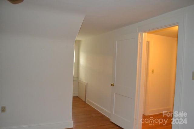 corridor with hardwood / wood-style flooring