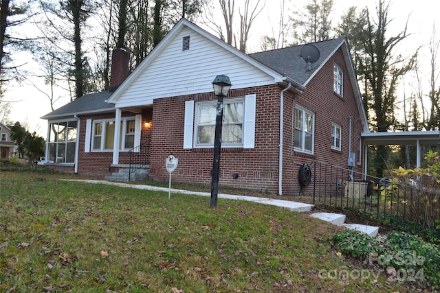 view of front of house with a sunroom and a front lawn