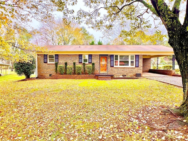 ranch-style home featuring driveway, brick siding, an attached carport, crawl space, and a front yard