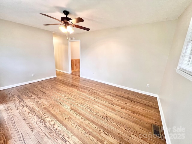 empty room with light wood-type flooring, baseboards, visible vents, and a ceiling fan