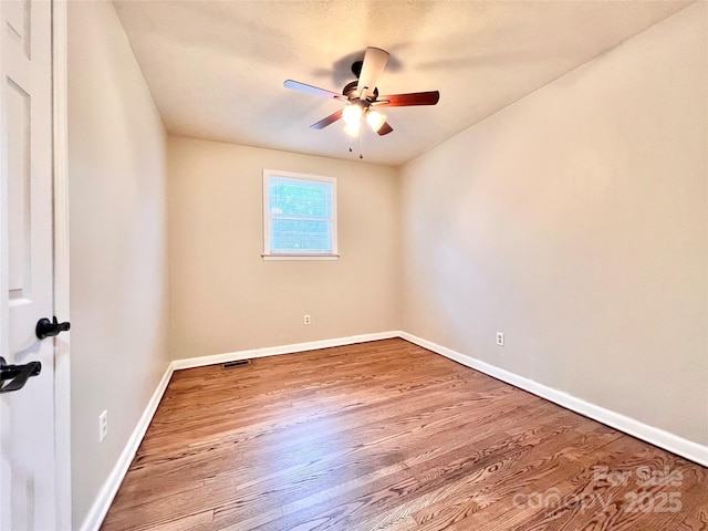 unfurnished room with ceiling fan, baseboards, and wood finished floors