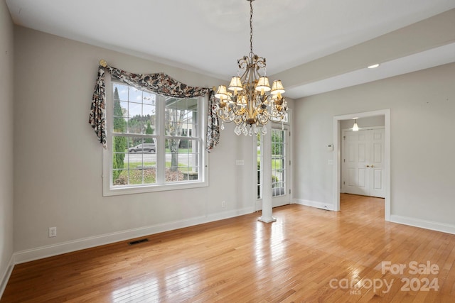 unfurnished dining area featuring a chandelier and light hardwood / wood-style floors