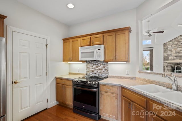 kitchen with vaulted ceiling, ceiling fan, sink, hardwood / wood-style flooring, and black electric range oven