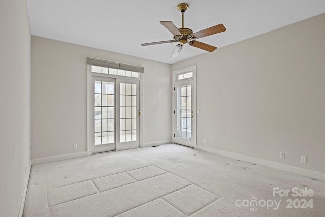 carpeted spare room with ceiling fan