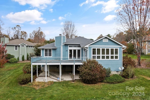 rear view of house with a wooden deck and a yard