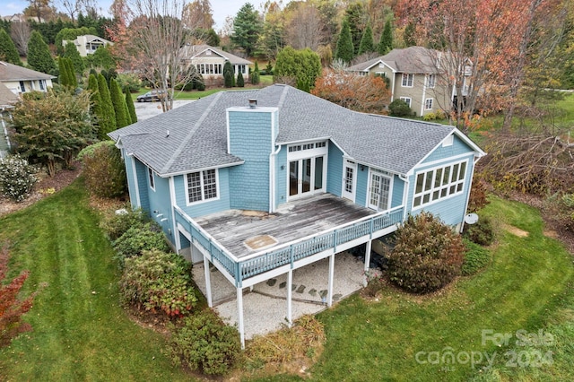 rear view of property featuring a lawn and a wooden deck