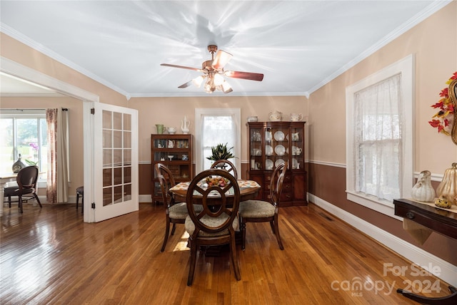 dining area with a wealth of natural light, hardwood / wood-style floors, and crown molding