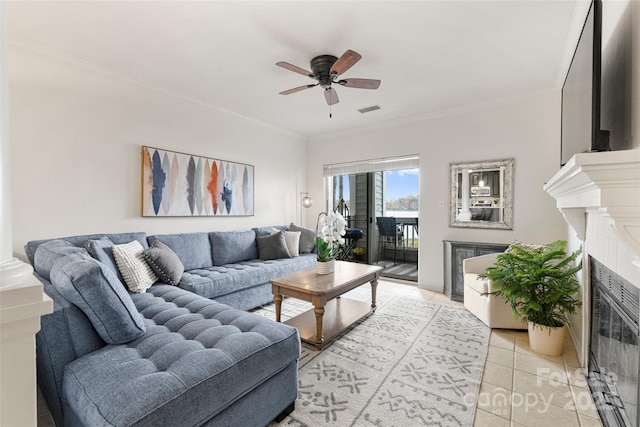 tiled living room featuring ceiling fan, a high end fireplace, and crown molding