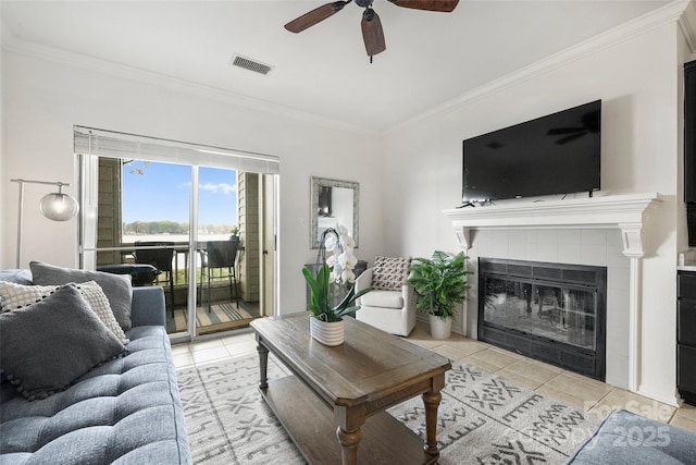 living room featuring a fireplace, light tile patterned floors, and crown molding