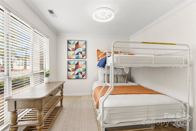 bedroom featuring light colored carpet, ornamental molding, and multiple windows