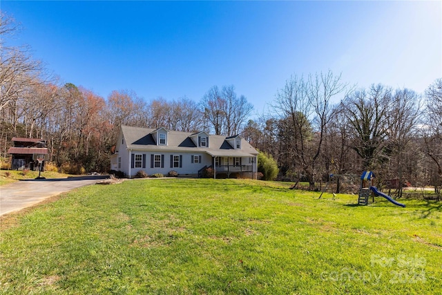 cape cod home featuring a playground and a front yard