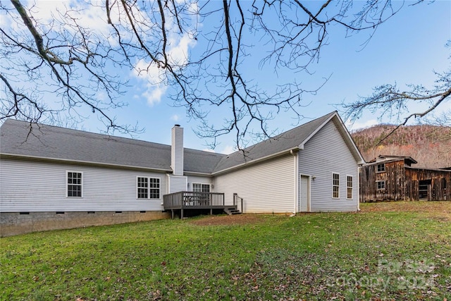 back of house with a lawn and a deck