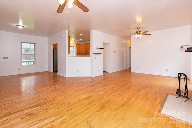 unfurnished living room with light hardwood / wood-style flooring and ceiling fan