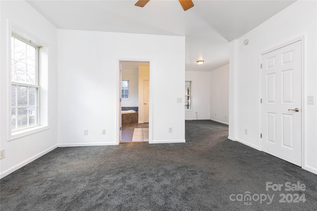 empty room featuring ceiling fan and dark carpet