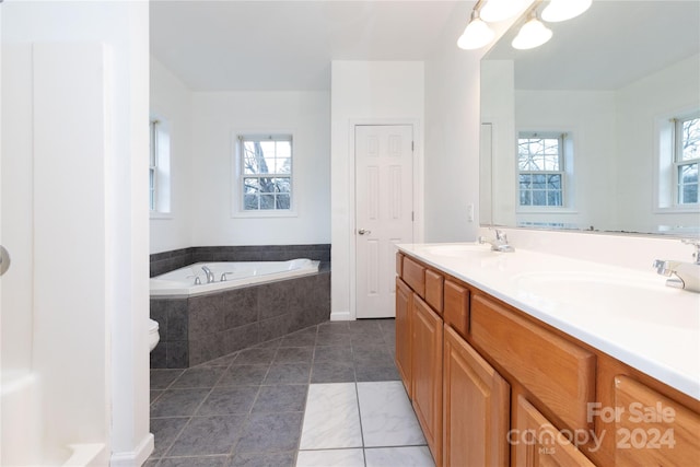 bathroom featuring vanity, tile patterned floors, and tiled tub