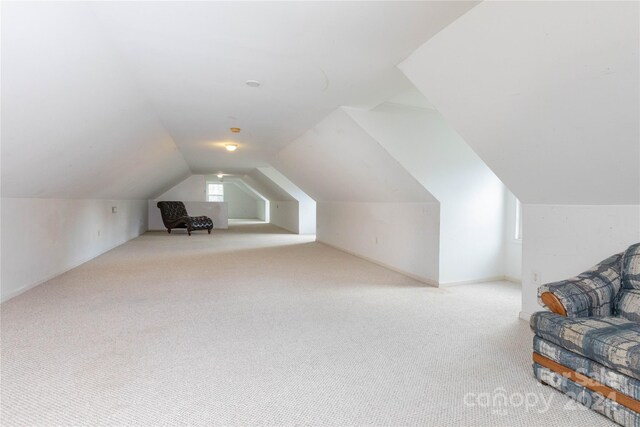 bonus room featuring light colored carpet and vaulted ceiling