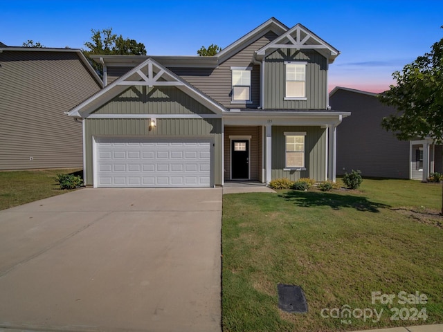 craftsman inspired home featuring a garage and a lawn