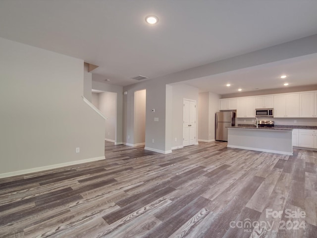 unfurnished living room with light hardwood / wood-style flooring and sink