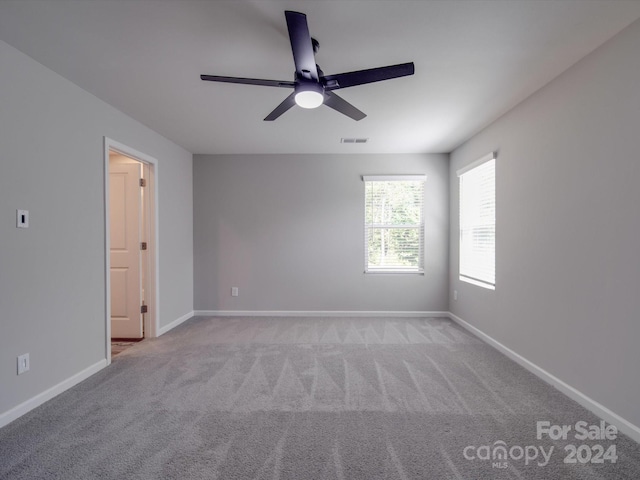 carpeted spare room with ceiling fan