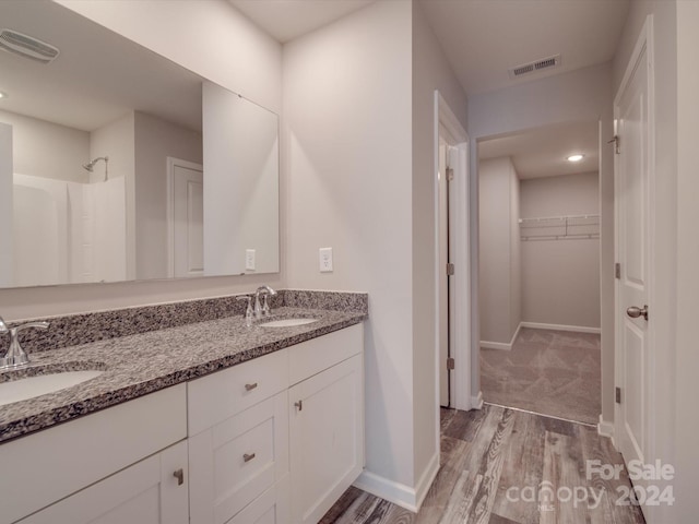 bathroom with a shower, vanity, and hardwood / wood-style flooring