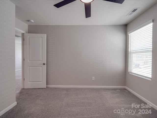 carpeted empty room featuring ceiling fan and a wealth of natural light