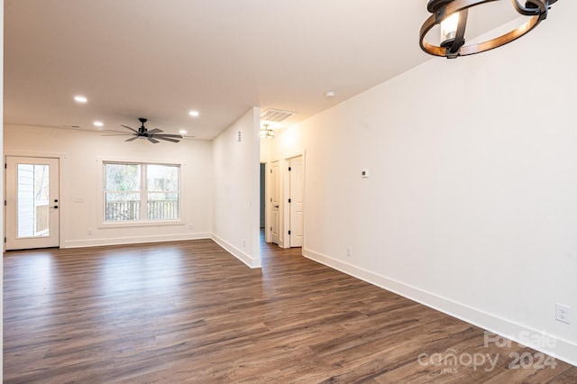 unfurnished living room with dark hardwood / wood-style floors and ceiling fan