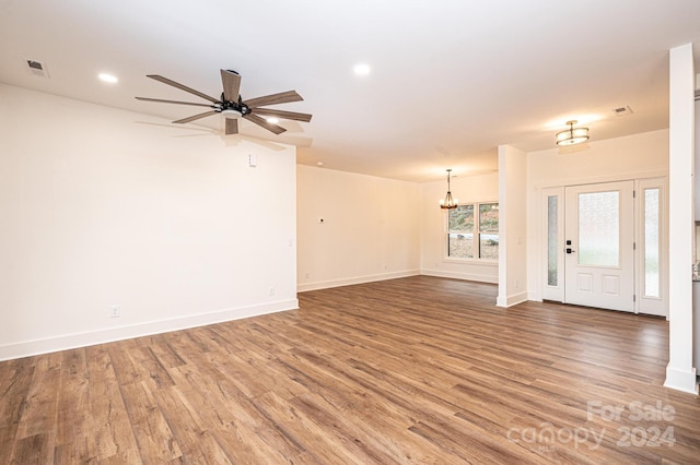 interior space with hardwood / wood-style floors and ceiling fan with notable chandelier