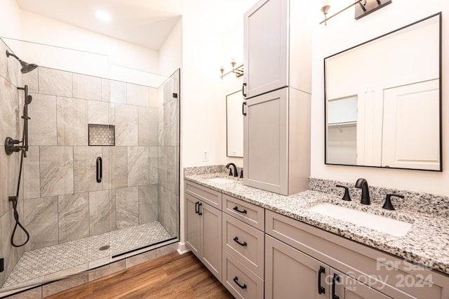 bathroom with a shower with door, vanity, and wood-type flooring