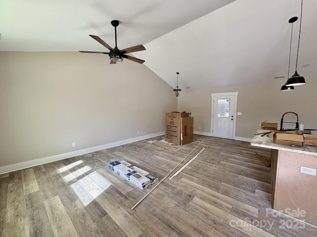 unfurnished living room featuring wood-type flooring, vaulted ceiling, and ceiling fan