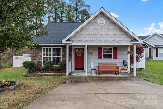 view of front of house with a porch and a front lawn