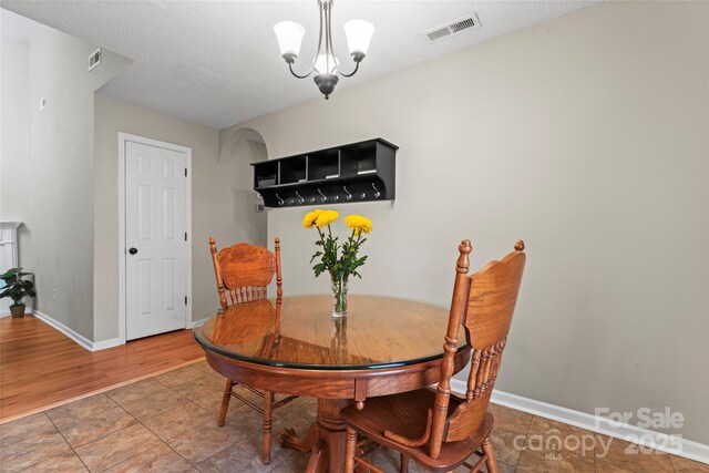 dining space with a chandelier, visible vents, and baseboards