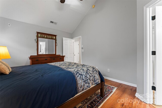 bedroom with visible vents, ceiling fan, wood finished floors, high vaulted ceiling, and baseboards