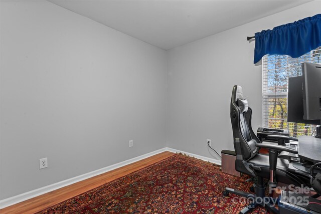 office space with baseboards and wood finished floors