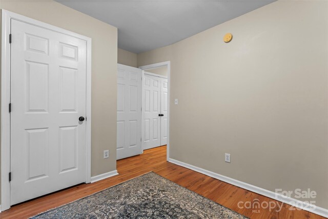 unfurnished bedroom with baseboards and wood finished floors