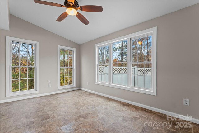 empty room featuring vaulted ceiling, a ceiling fan, and baseboards