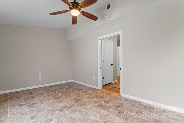 empty room featuring a ceiling fan, visible vents, and baseboards