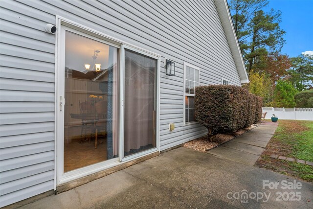 property entrance with a patio area and fence