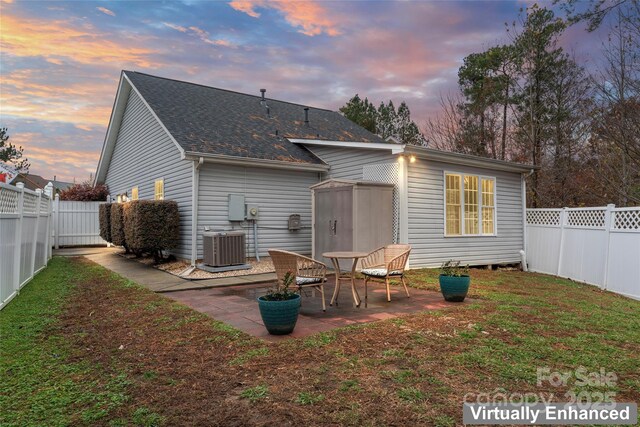 back of house with a yard, a fenced backyard, a patio, and central AC unit