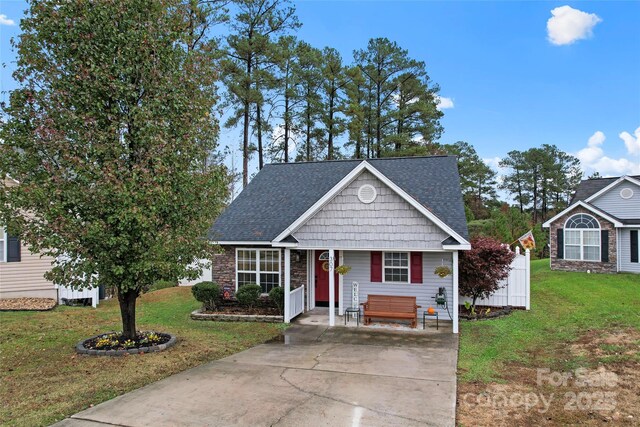 view of front of home with a front yard and roof with shingles