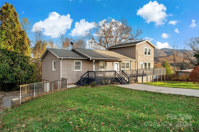 view of front facade featuring a front yard and a deck