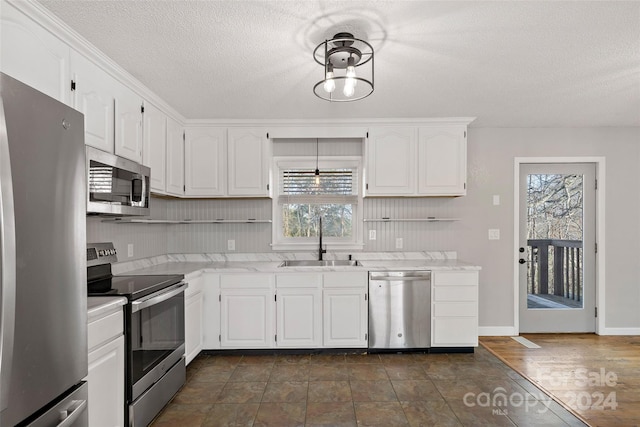 kitchen with white cabinets, a textured ceiling, stainless steel appliances, and sink