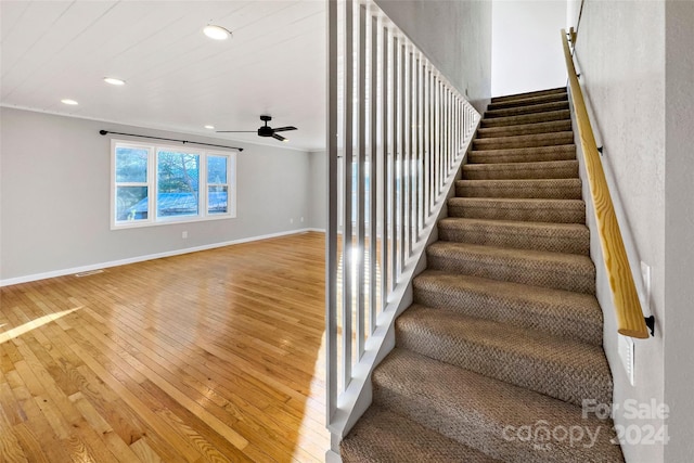 staircase featuring hardwood / wood-style flooring and ceiling fan