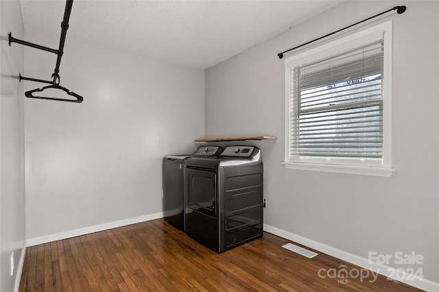 washroom featuring washer and dryer, dark hardwood / wood-style flooring, and a textured ceiling