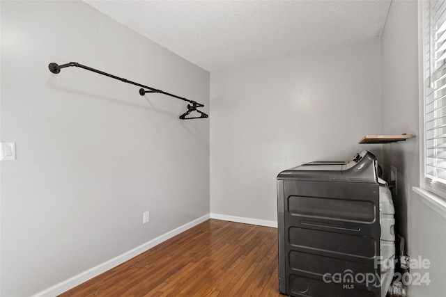 laundry area featuring a textured ceiling, washer / dryer, and dark wood-type flooring