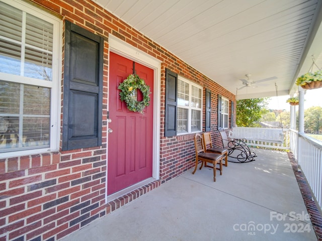 entrance to property with ceiling fan and covered porch