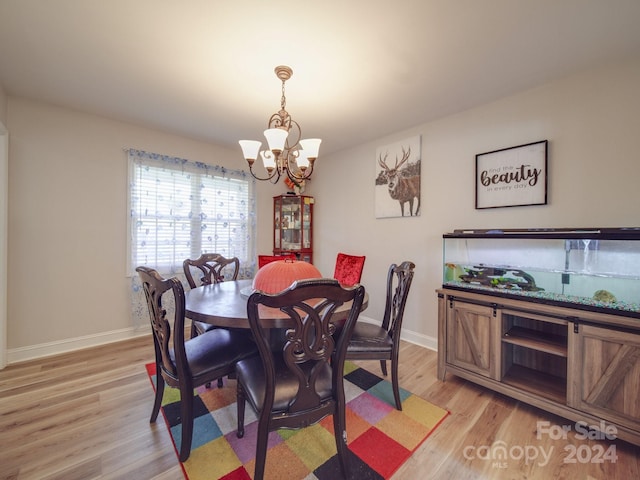 dining space featuring light hardwood / wood-style flooring and a notable chandelier