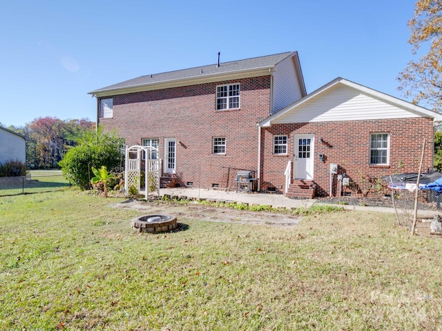 rear view of property featuring a lawn and an outdoor fire pit