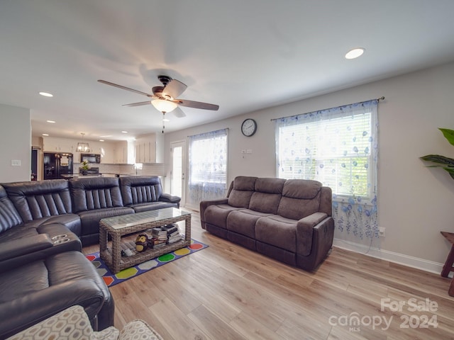 living room with ceiling fan and light hardwood / wood-style flooring