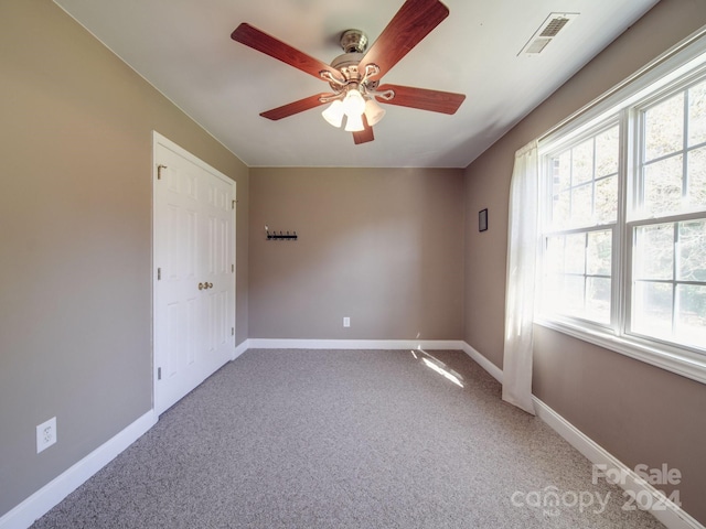 unfurnished room with carpet and ceiling fan